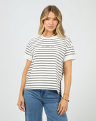 Woman wearing a striped t-shirt with 'All About Eve' text on a plain background