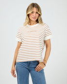 Woman wearing a striped t-shirt and blue jeans on a plain background
