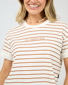 Woman wearing a striped shirt with 'All About Eve' text on a plain background