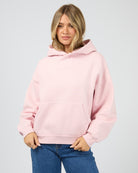Person wearing a pink hoodie against a plain background