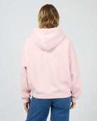 Person wearing a pink hoodie from behind on a light gray background