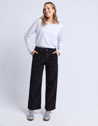 Woman wearing a white shirt and black pants on a white background