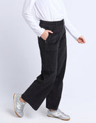 Person wearing black pants and a white shirt on a white background
