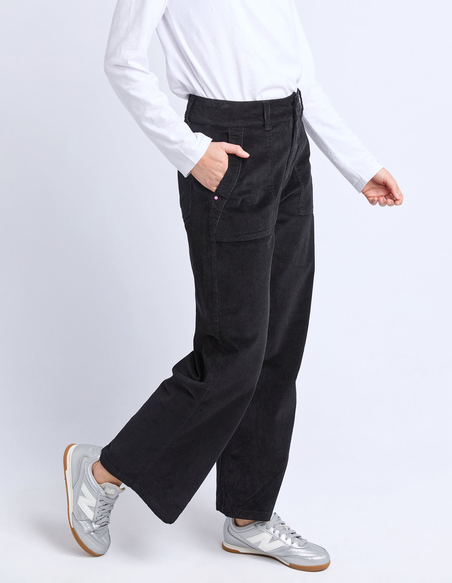 Person wearing black pants and a white shirt on a white background