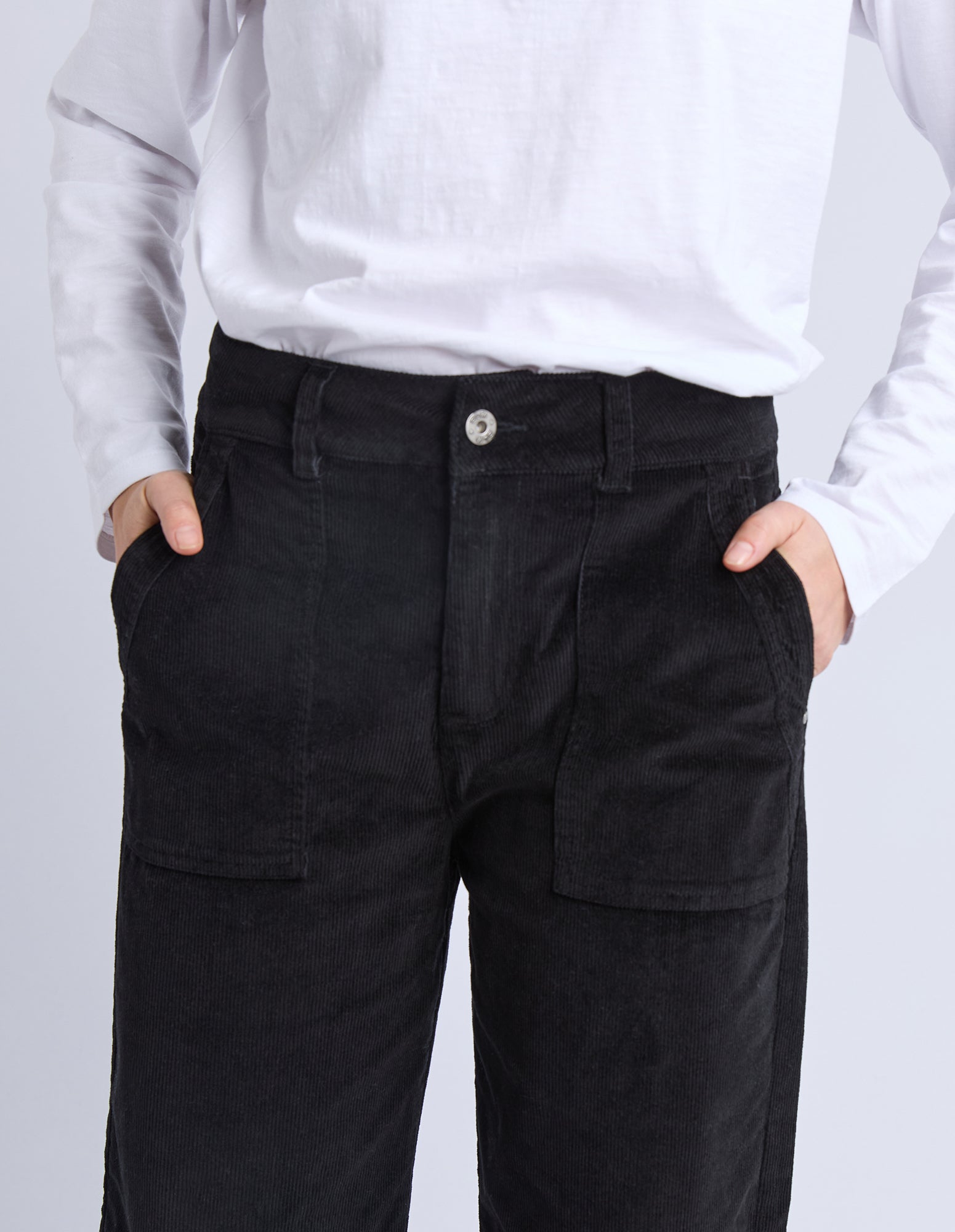 Person wearing black cargo pants with a plain background