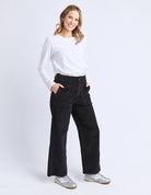 Woman wearing a white shirt and black pants on a white background