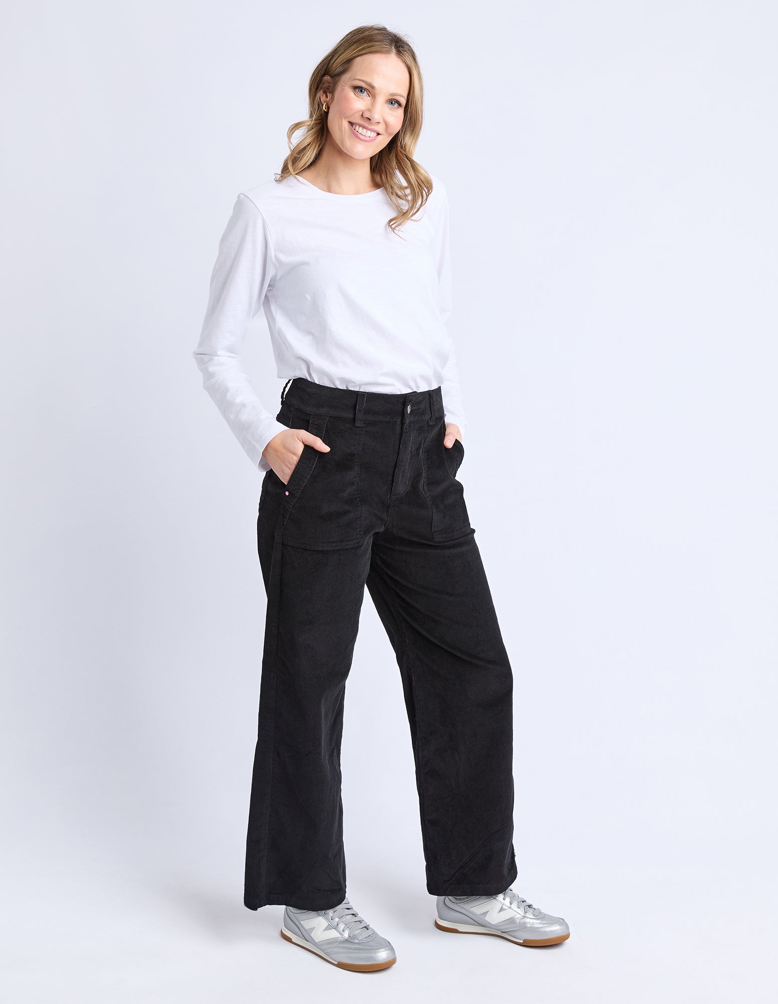 Woman wearing a white shirt and black pants on a white background