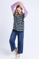 Person wearing a striped shirt and blue jeans on a white background