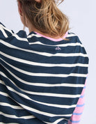 Navy and white striped shirt with colorful sleeves on a plain background