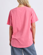 Person wearing a pink t-shirt on a light gray background