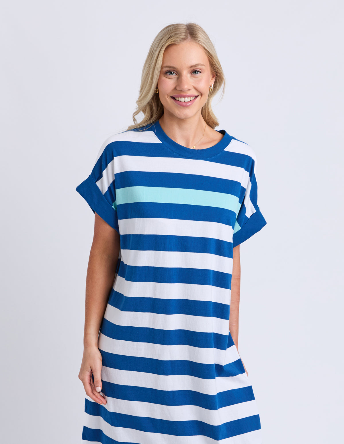 Woman wearing a blue and white striped dress on a plain background