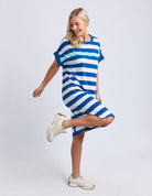 Woman wearing a blue and white striped dress on a plain background