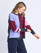 Woman wearing a colorful sweater with a white background