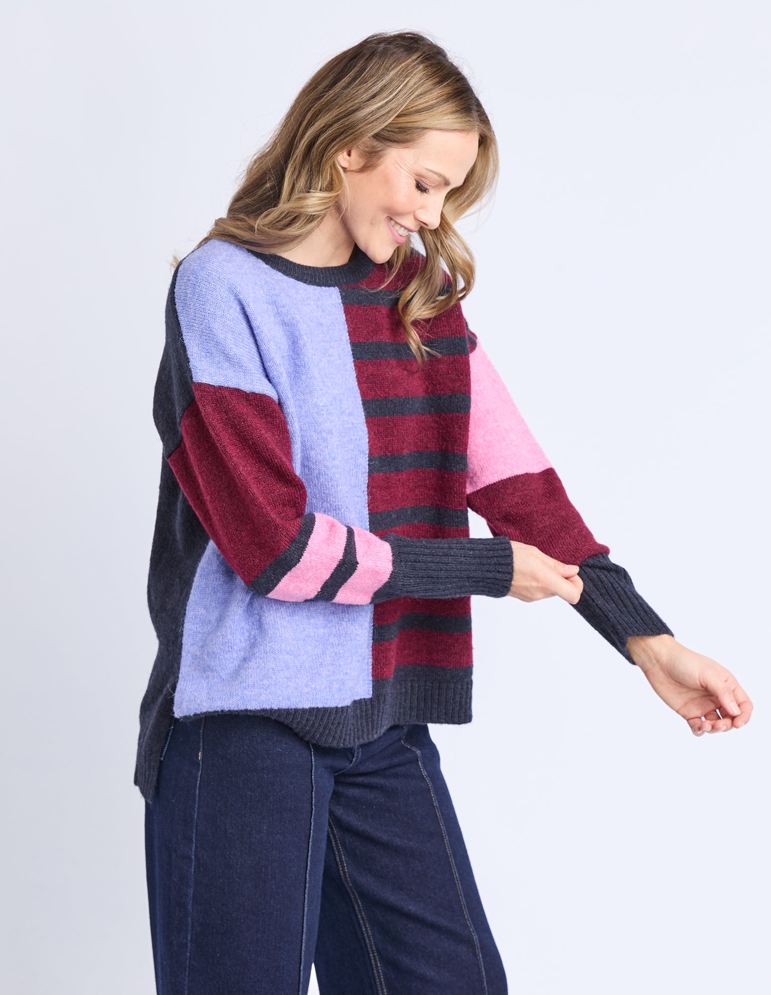Woman wearing a colorful sweater with a white background