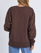Brown sweatshirt worn by a person on a plain background