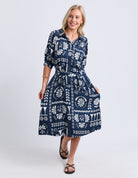 Woman wearing a blue patterned dress on a white background