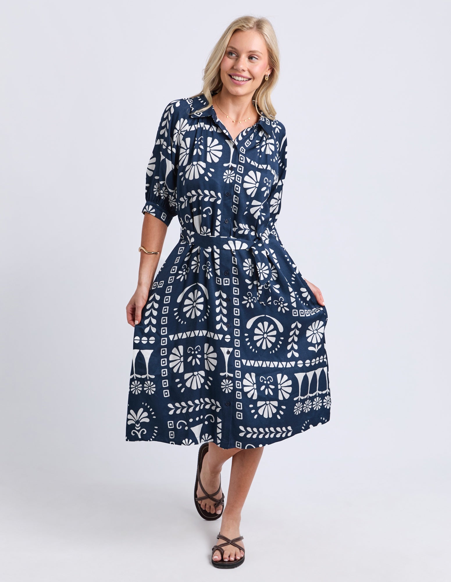 Woman wearing a blue patterned dress on a white background