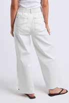 White wide-leg cropped jeans with an elastic waistband, shown from the back on a model wearing black flip-flops against a light gray studio background.