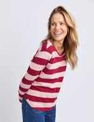 Woman wearing a red and white striped sweater on a plain background