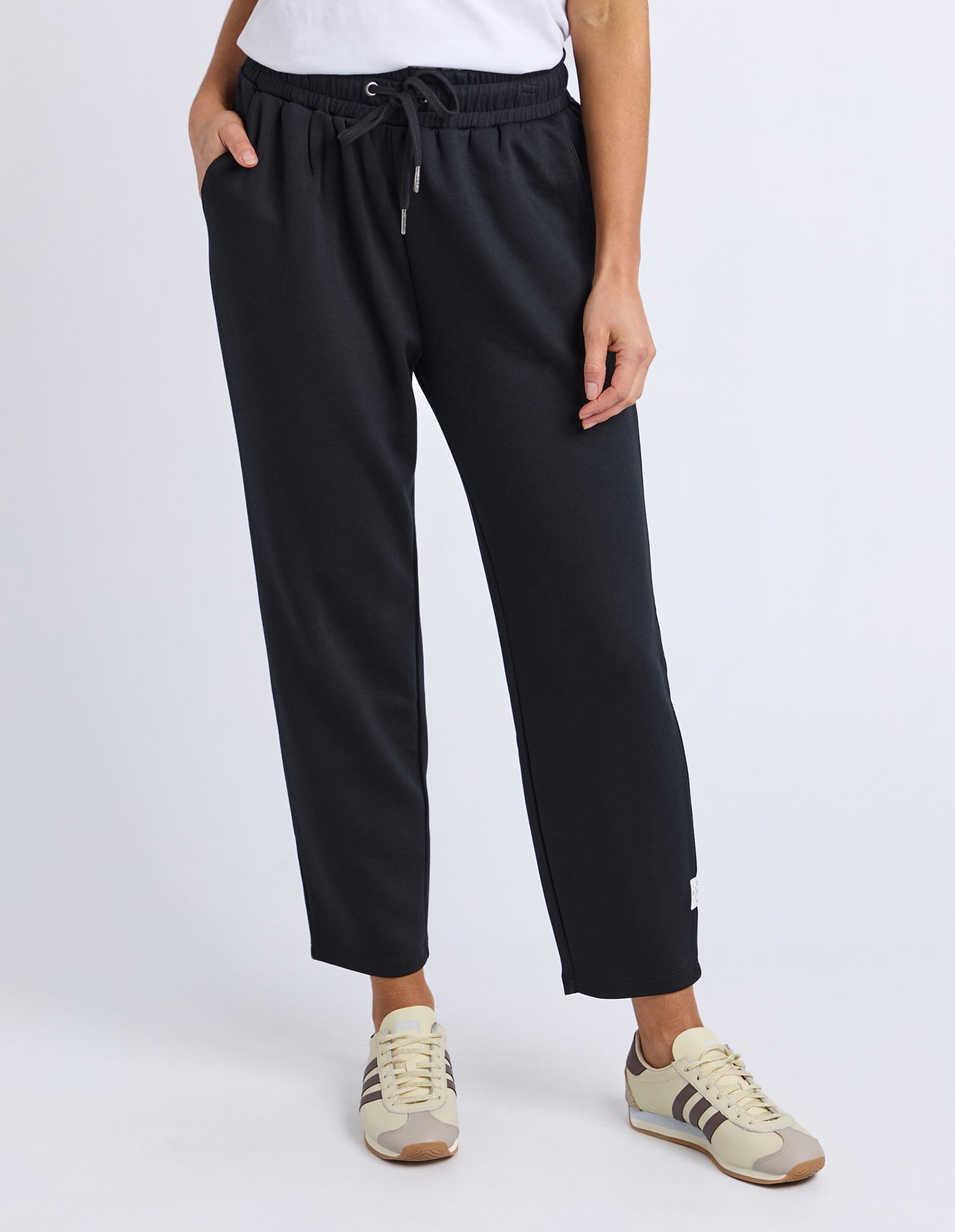 Person wearing black pants with a white background