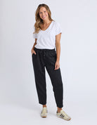Woman wearing a white t-shirt and black pants on a white background
