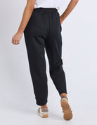 Person wearing black jogger pants on a white background