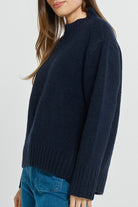 Navy sweater worn by a person on a white background