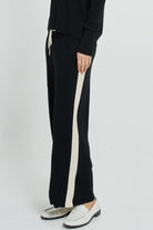 Black pants with a white stripe on a white background