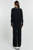 Person wearing a black outfit with white stripes on a white background