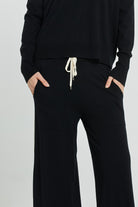 Black outfit with a drawstring waist on a light gray background