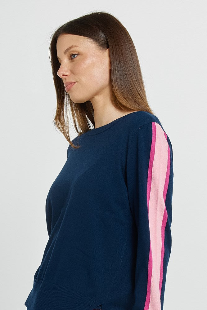 Woman wearing a navy blue sweatshirt with pink stripes on a white background