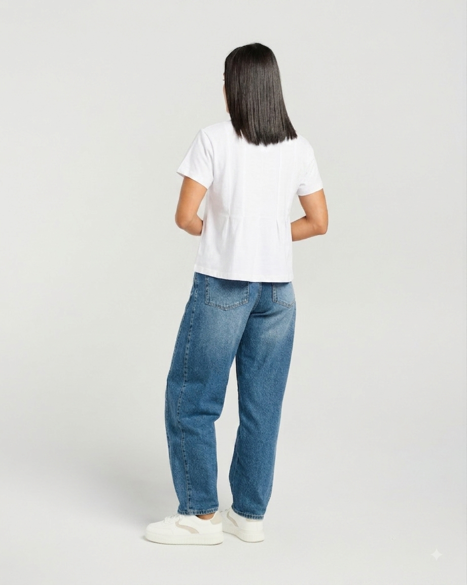 A woman is shown from the back wearing a white short-sleeve crop top, blue jeans, and white sneakers against a light gray studio background.