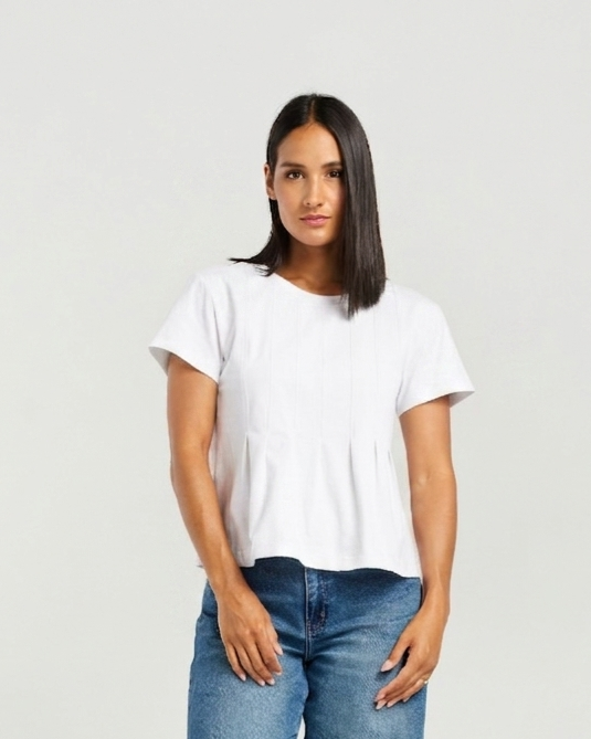 A woman modeling a white short-sleeve crewneck top with a subtle peplum hem, paired with blue jeans, against a plain light gray background.