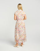 Woman wearing a floral dress on a plain background