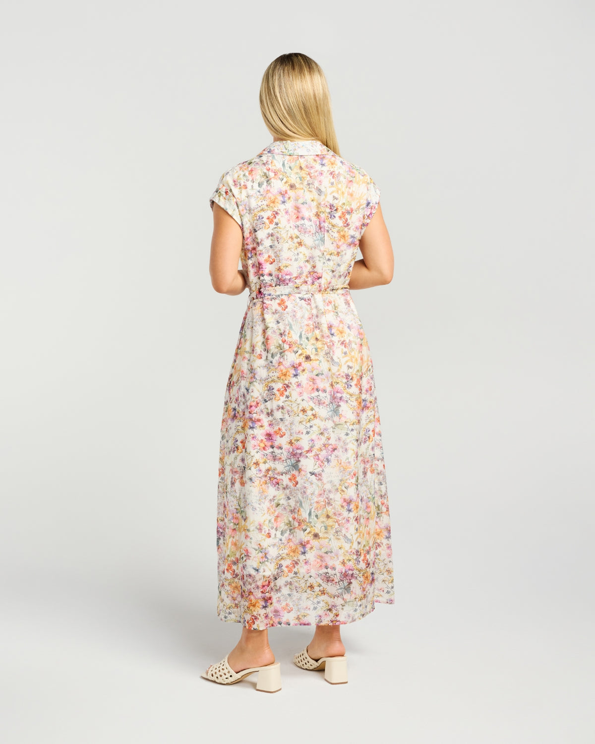 Woman wearing a floral dress on a plain background