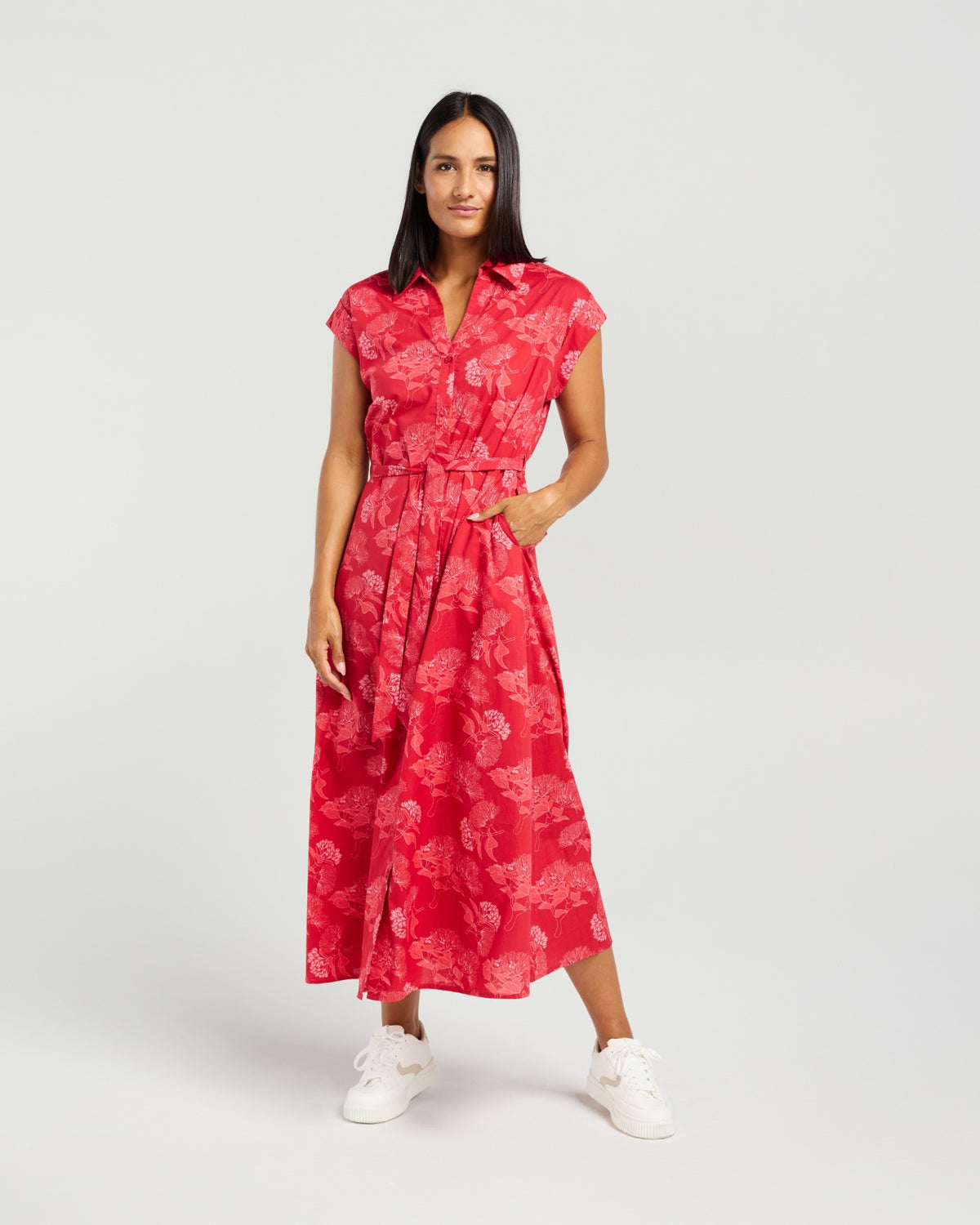 Woman wearing a red floral dress on a white background