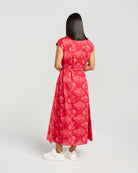 Woman wearing a red floral dress on a white background