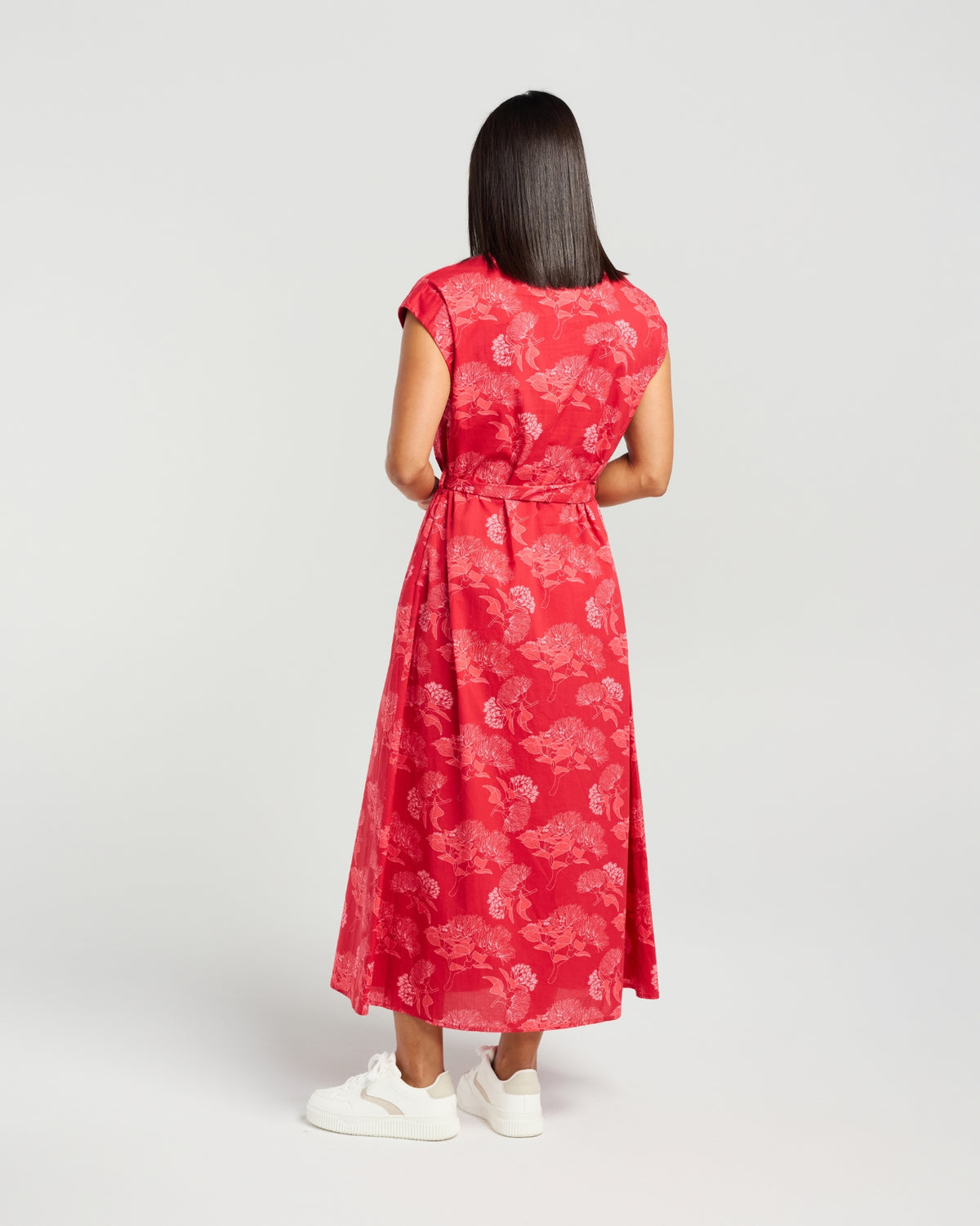 Woman wearing a red floral dress on a white background