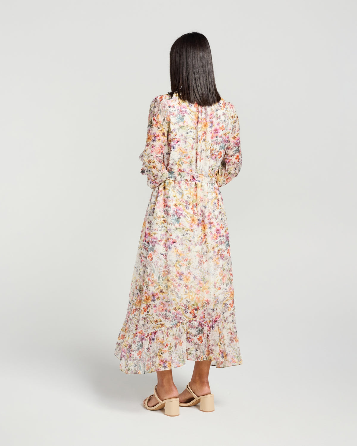 Woman wearing a floral dress on a plain background