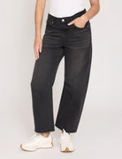 Person wearing black wide-leg jeans on a plain background