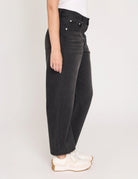 Person wearing black jeans on a plain background