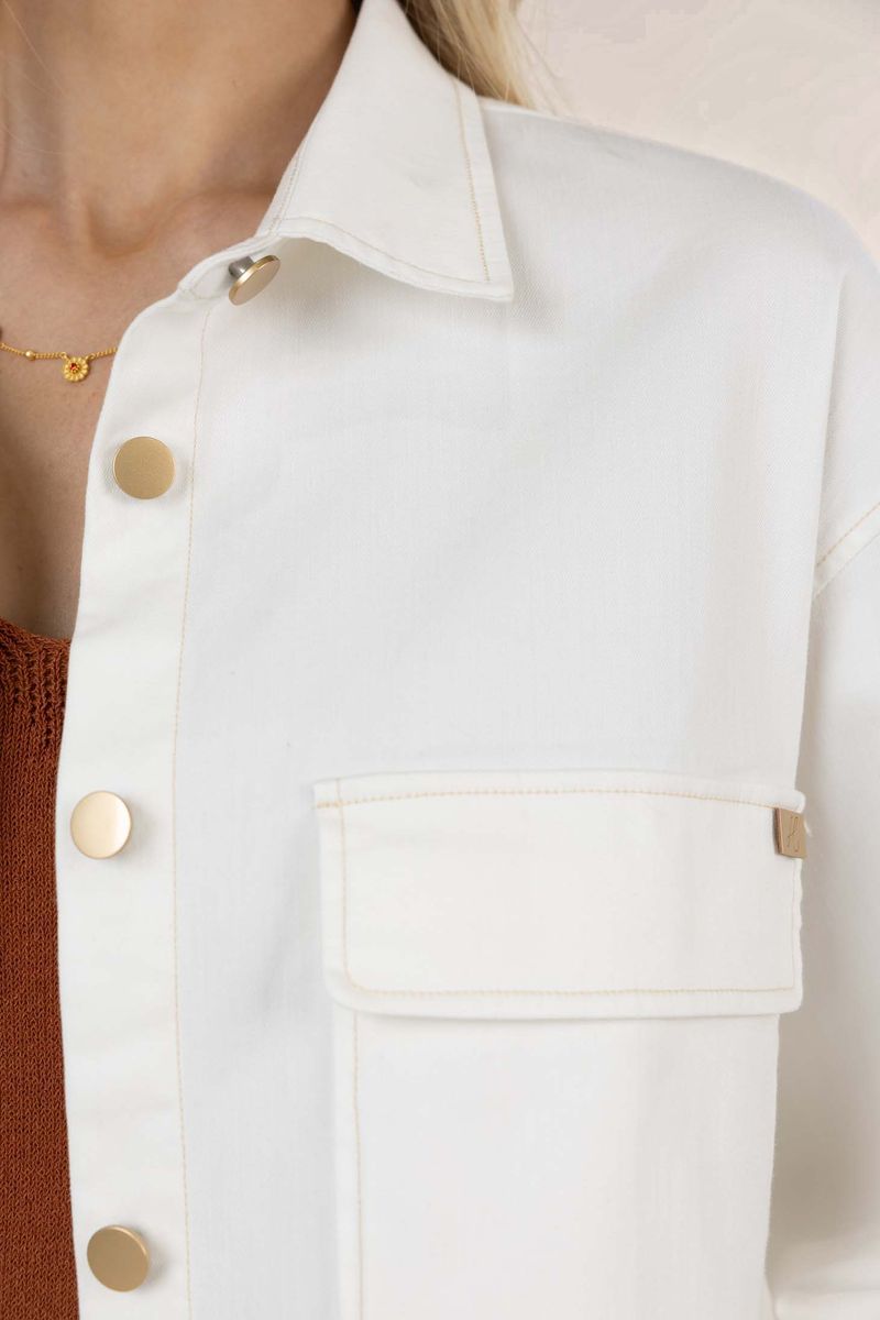 Close-up of a white jacket with gold buttons worn by a person.