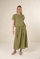 Woman wearing a green outfit on a beige background