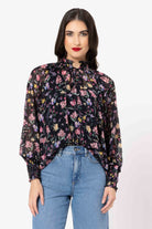 Woman wearing a floral blouse and blue jeans on a white background