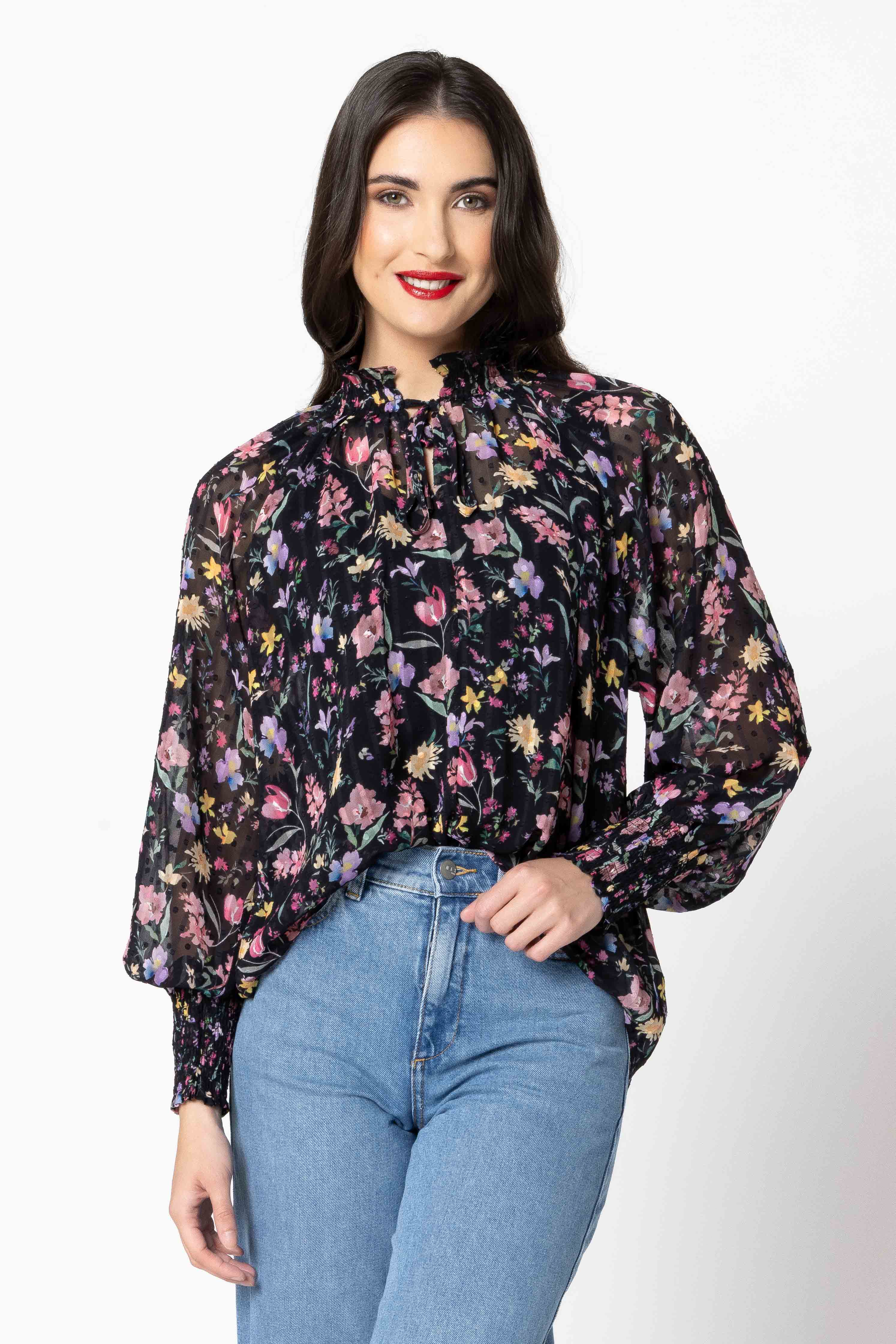 Woman wearing a floral blouse and jeans on a white background