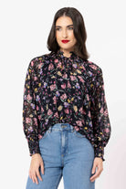 Woman wearing a floral blouse and blue jeans on a white background