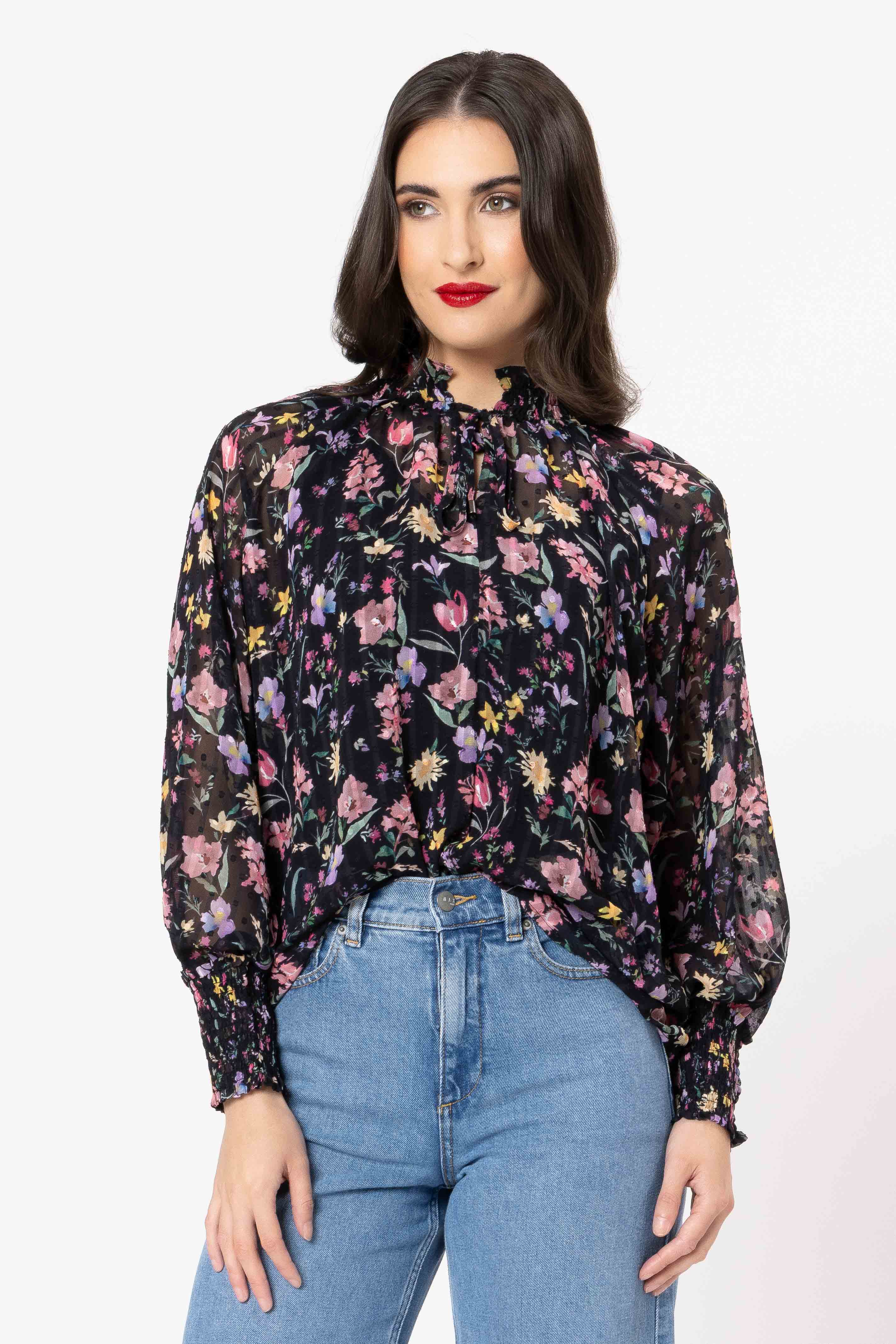 Woman wearing a floral blouse and blue jeans on a white background