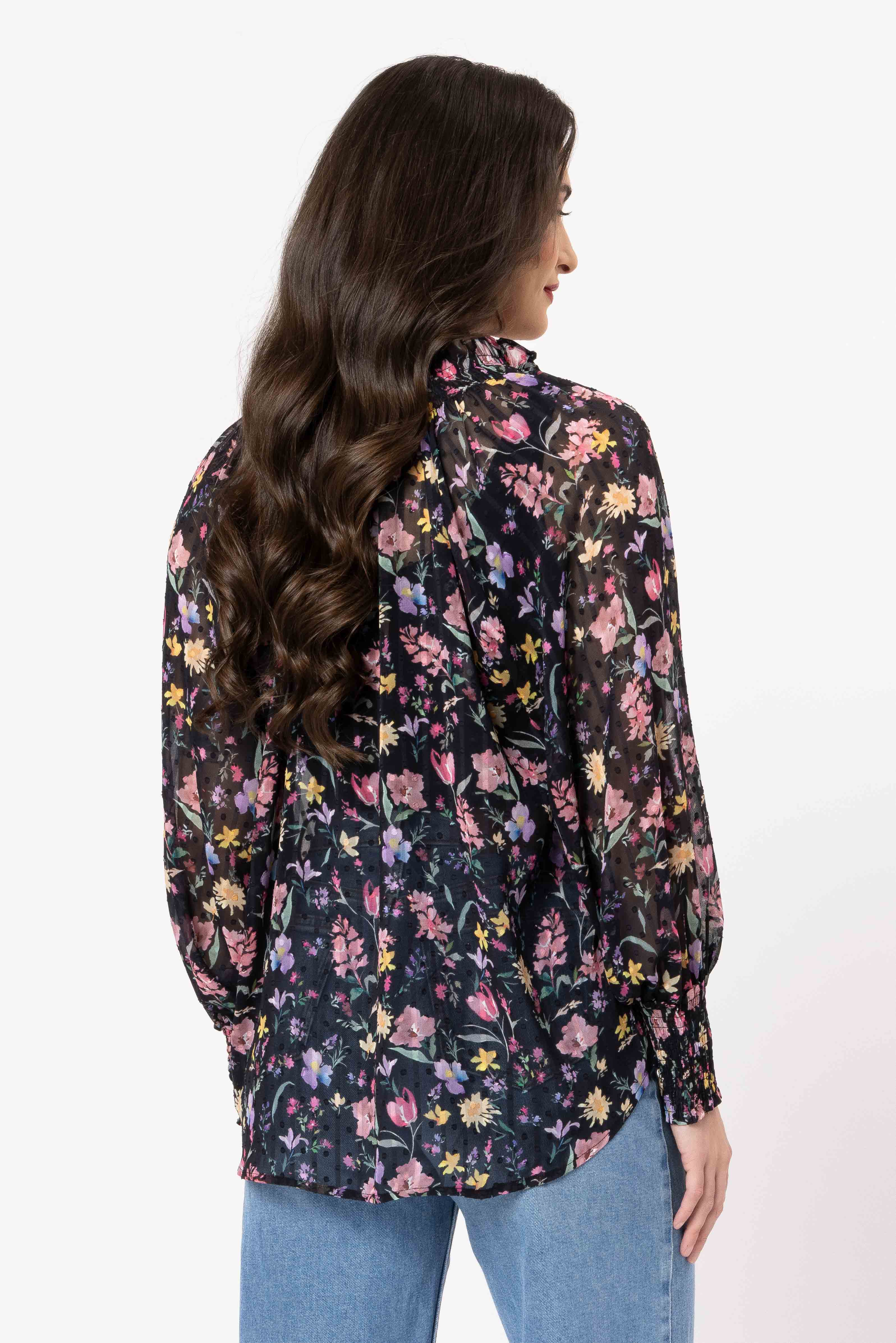 Woman wearing a floral patterned shirt on a white background