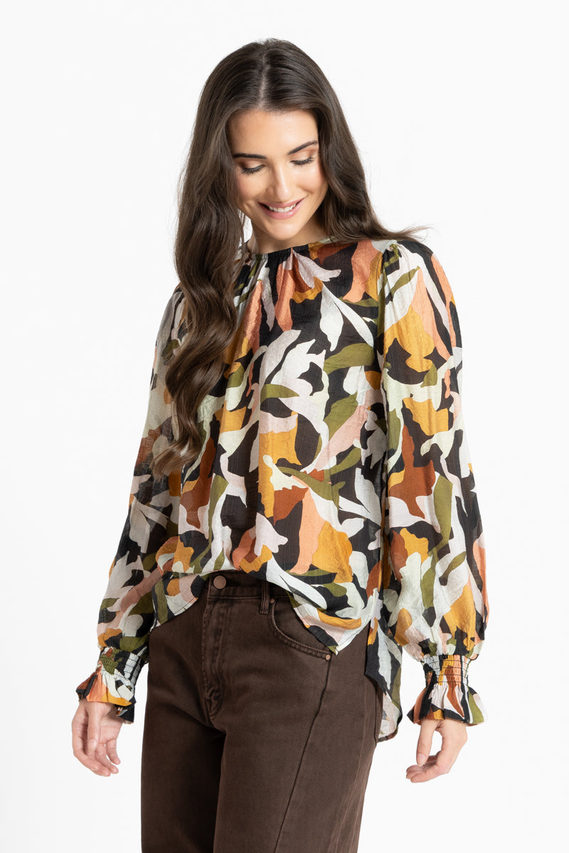 Woman wearing a patterned blouse with a white background