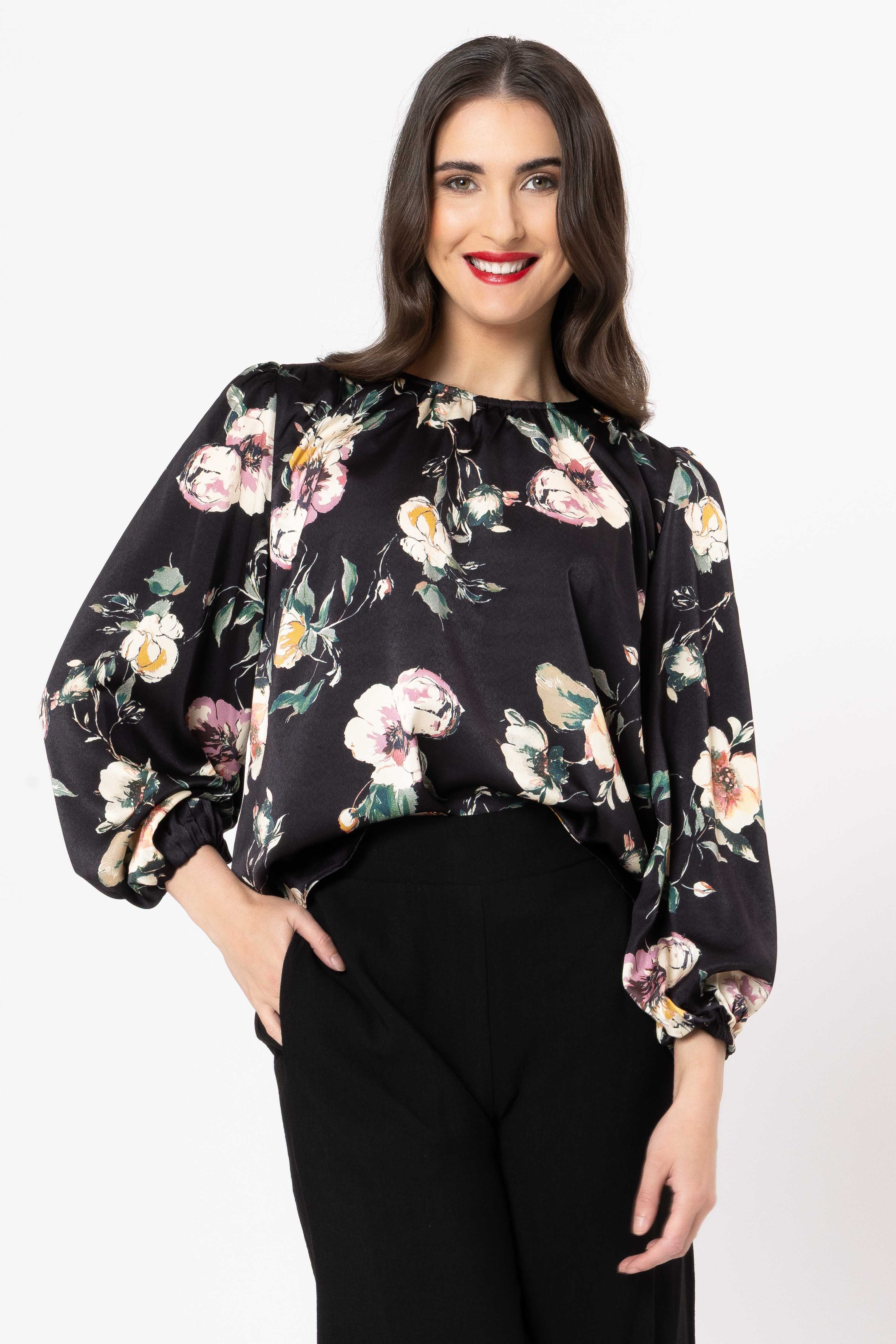 Woman wearing a black floral blouse against a white background
